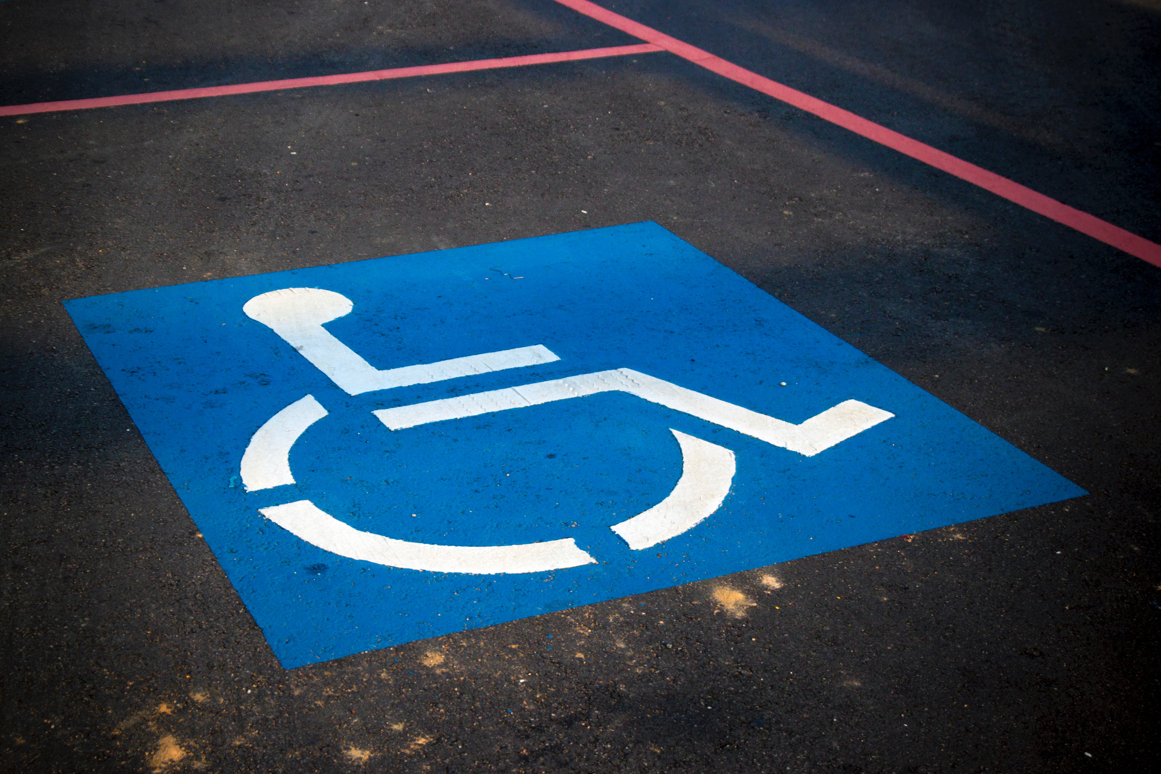 Wheelchair logo on the ground in blue and white in a parking space