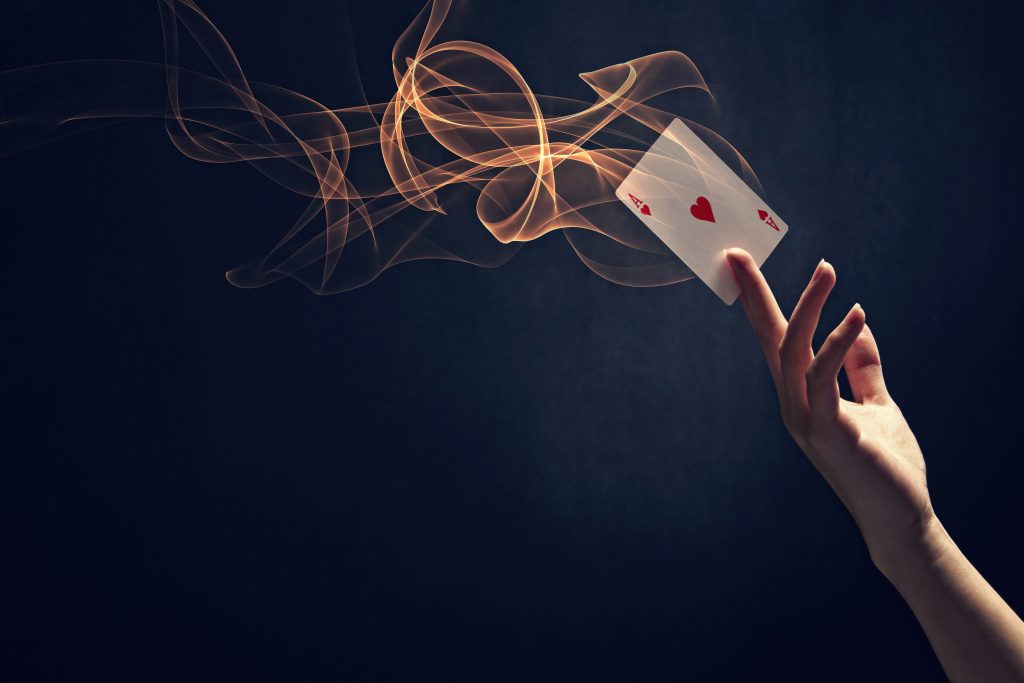 Female hand holding an ace card with flames coming off it