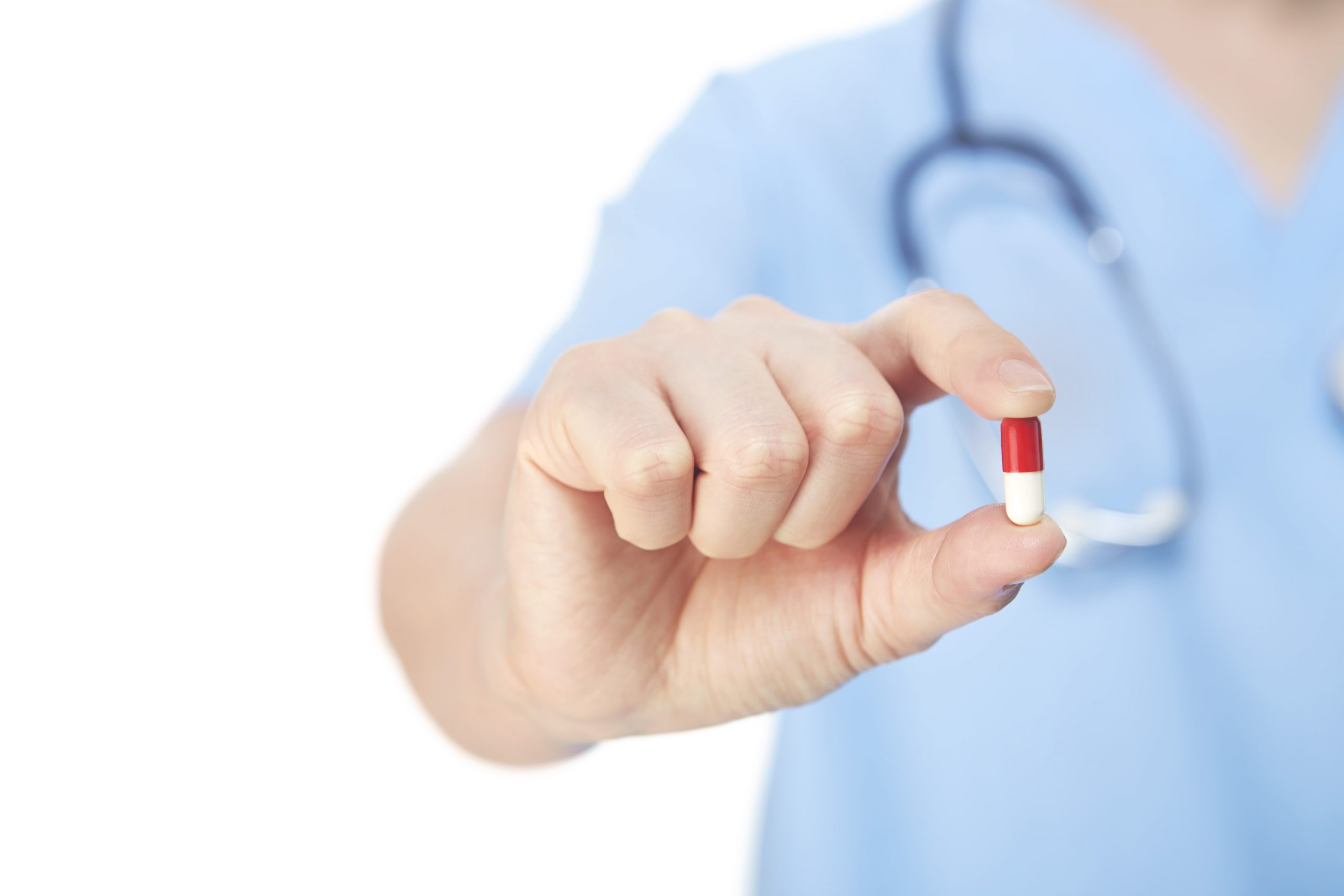 Doctor holding a red and white capsule