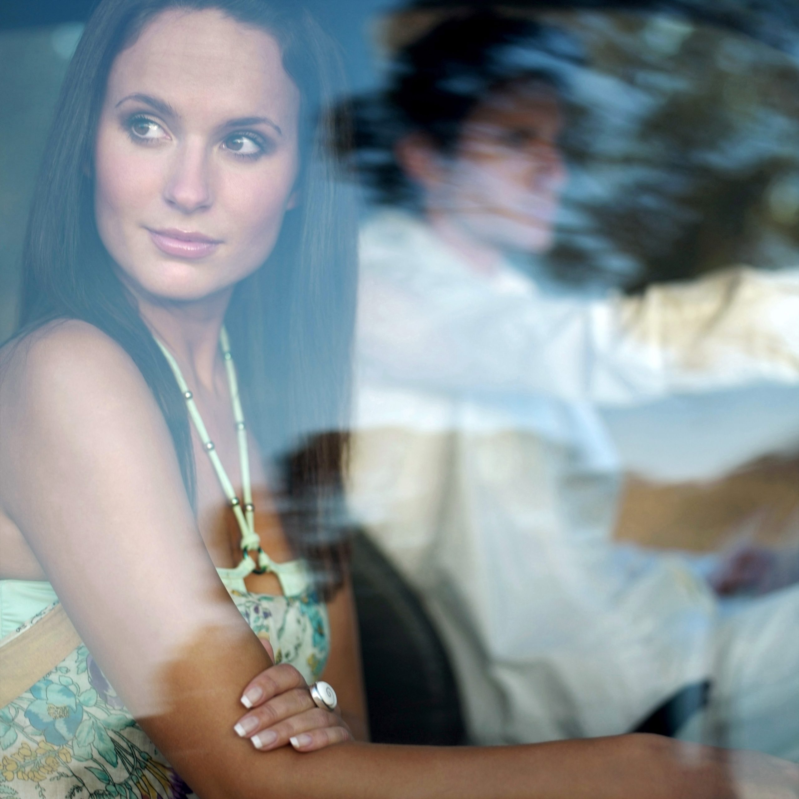 Woman and man travelling, woman looking out of the window as she is travelling with a disability