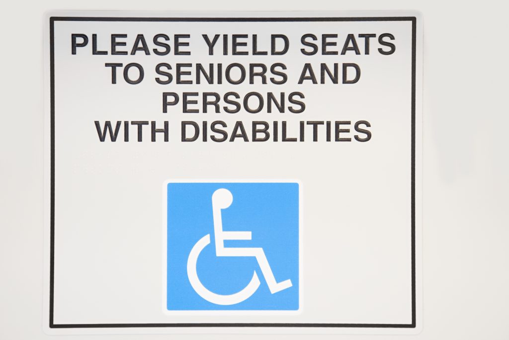 Disability sign saying - Please yield seats to seniors and persons with disabilities.