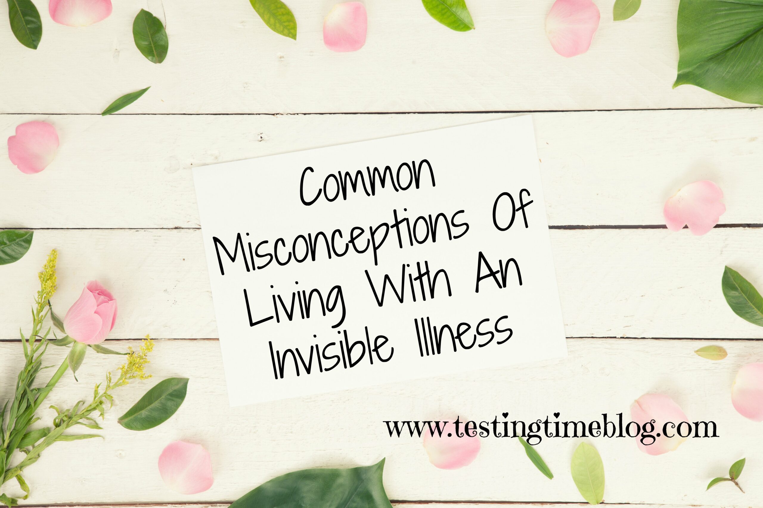 Common misconceptions of living with an invisible illness on a flat lay with cream wood, greenery and pink petals