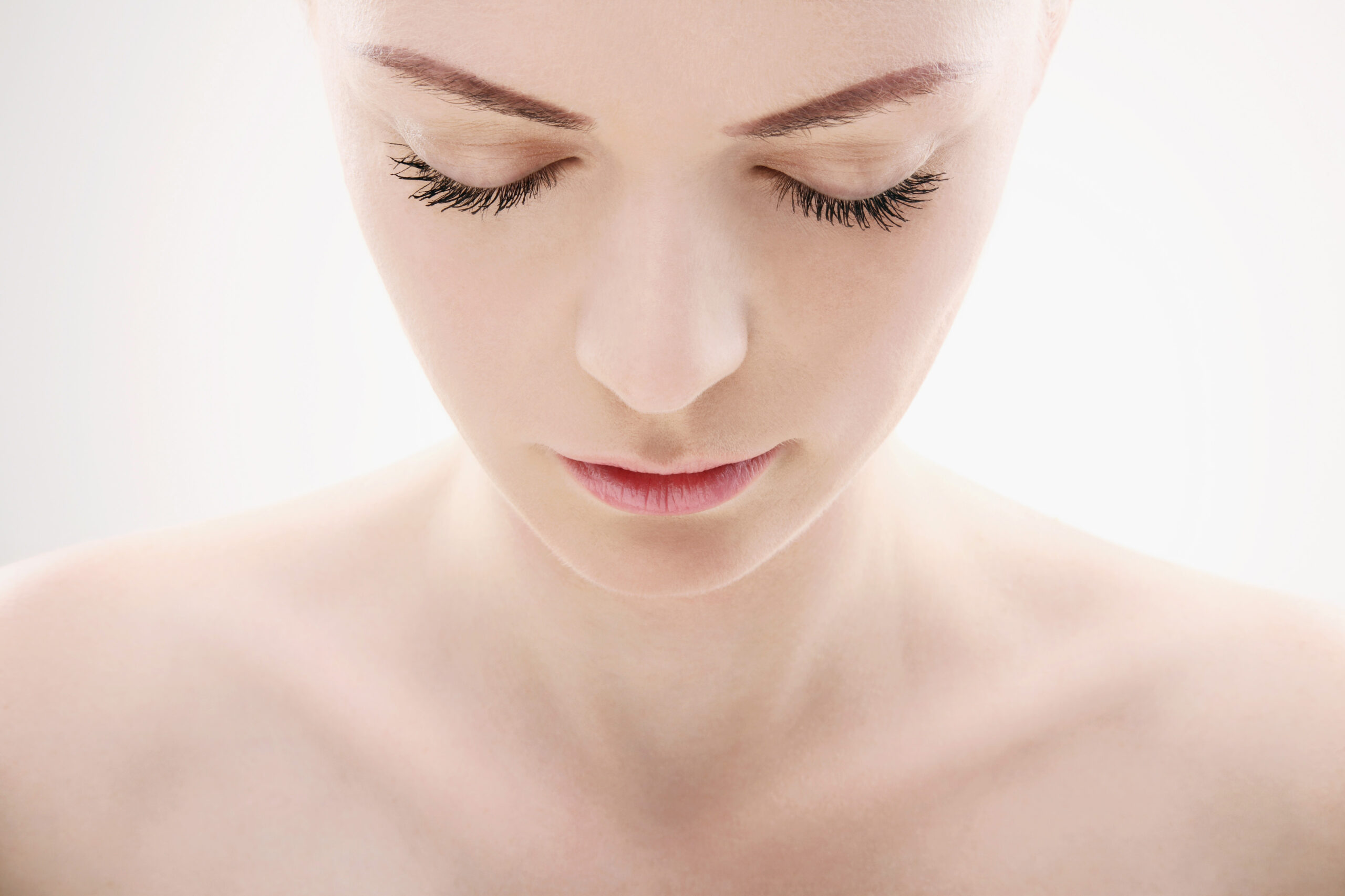Woman's head and shoulders with her looking down and eyes almost closed with skincare gift sets