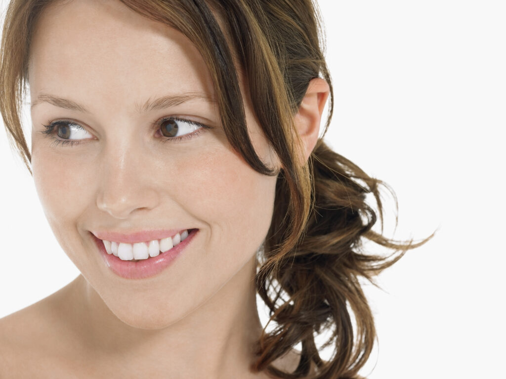 Fair skinned woman smiling with her hair tied to one side