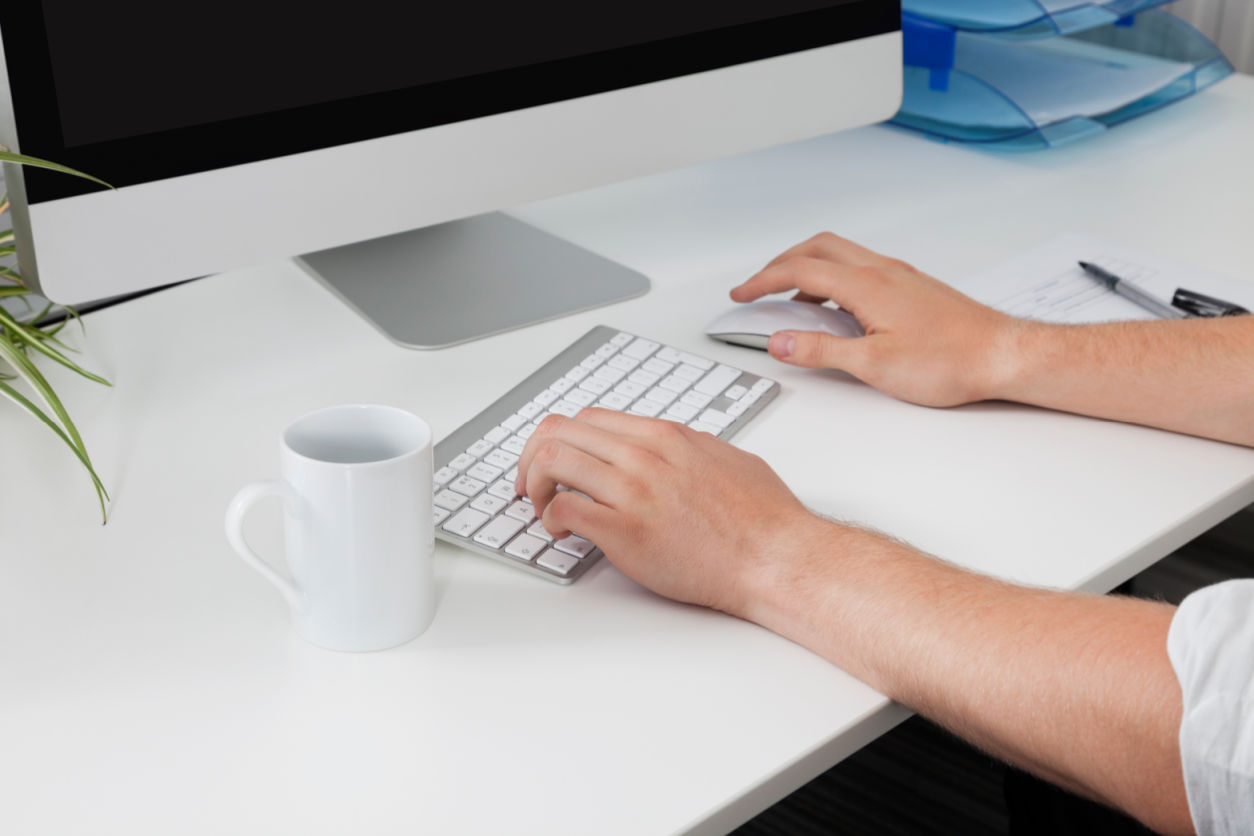Businessman's hands using computer at desk as Online Business Stand Out